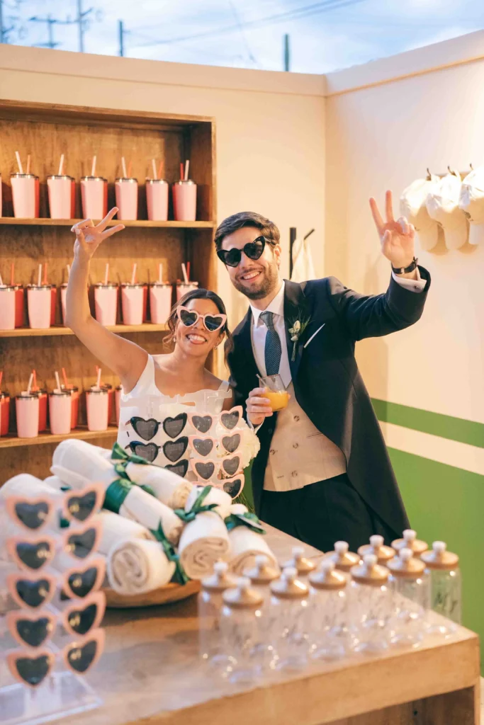Funciones de un wedding planner: Fotografía de una pareja de recién casados utilizando lentes en forma de corazón.